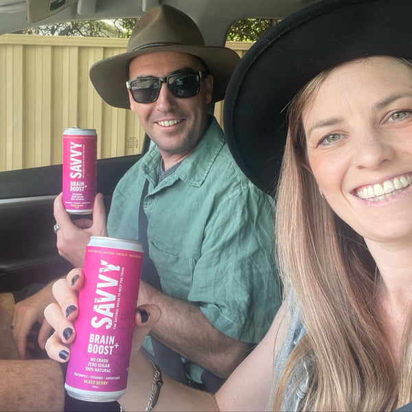 Two people in a car holding SAVVY Brain Boost cans